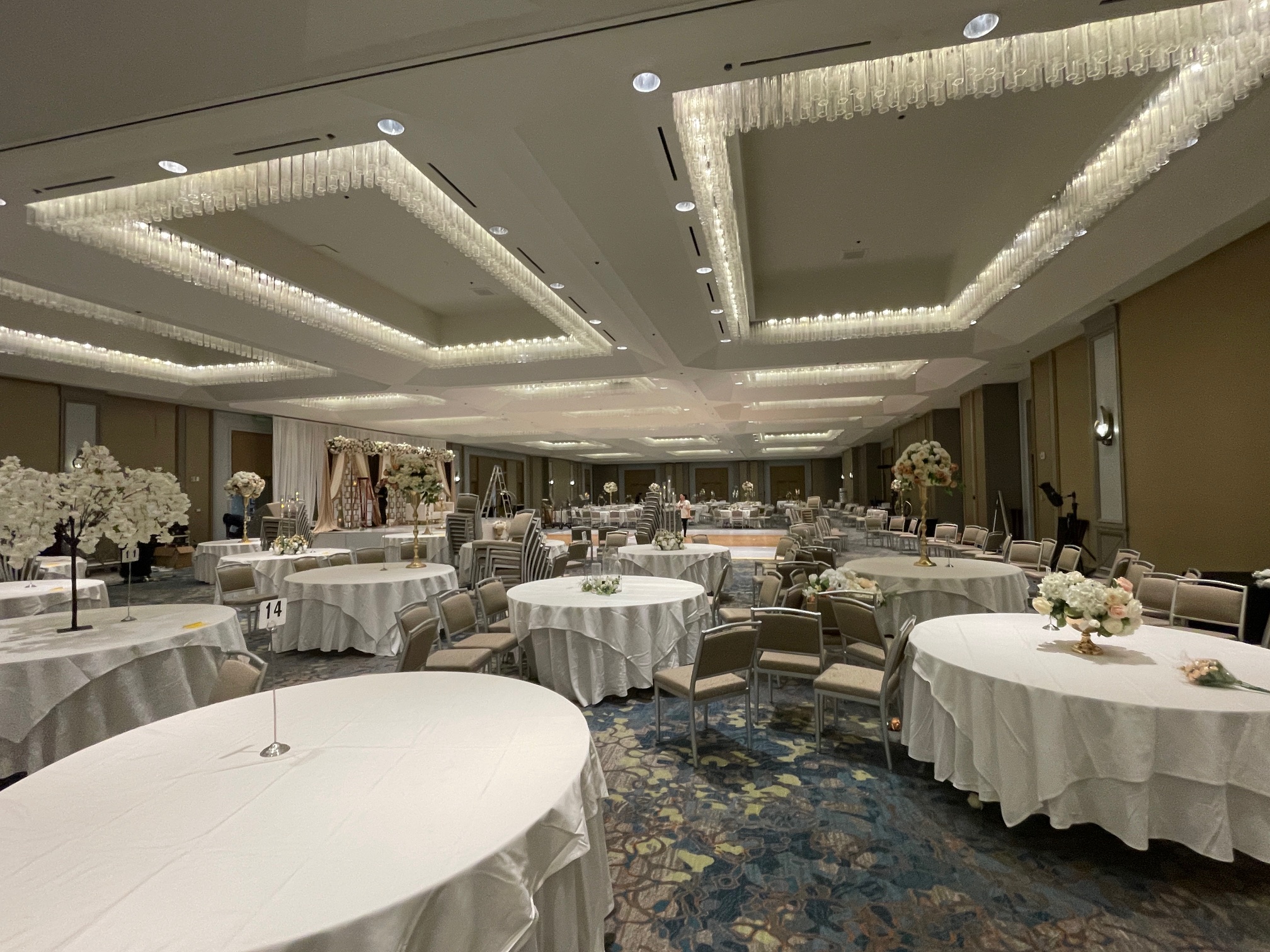 large ballroom with multiple round tables with white tablecloths